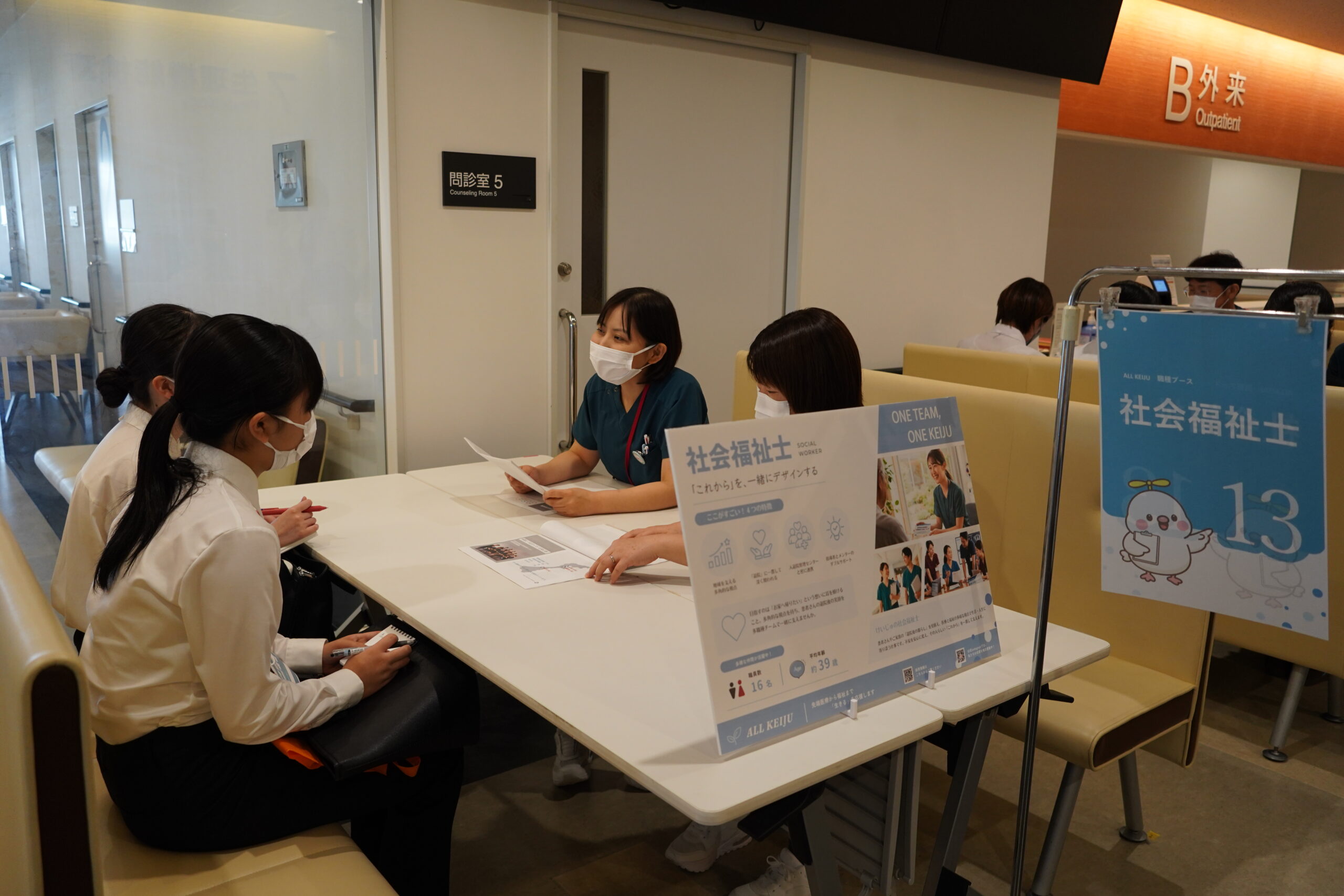 社会福祉士ブースで、職員が参加者に仕事の内容を説明している様子
