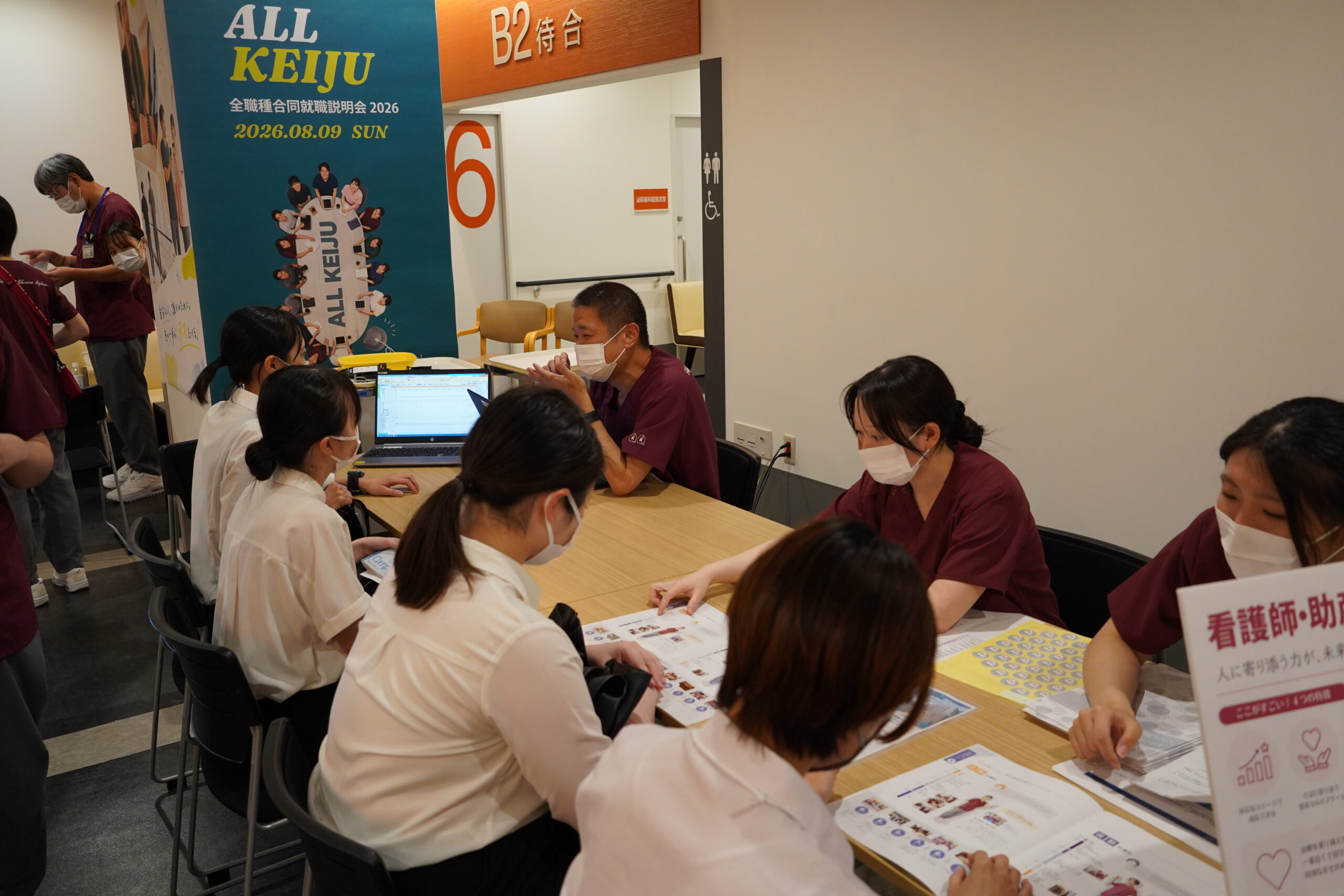 看護師ブースで、資料を広げながら複数の参加者と話している看護師たち
